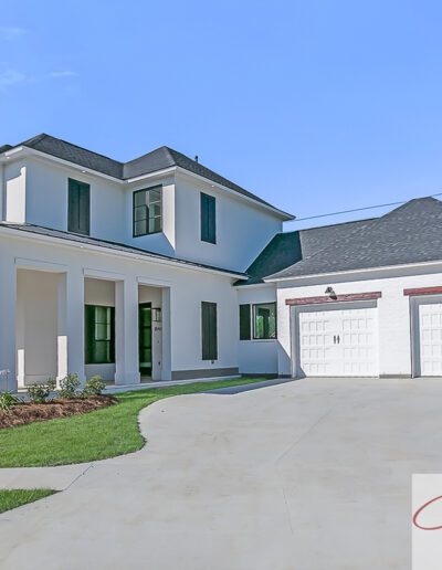 A modern two-story house with a detached garage and a well-manicured lawn.