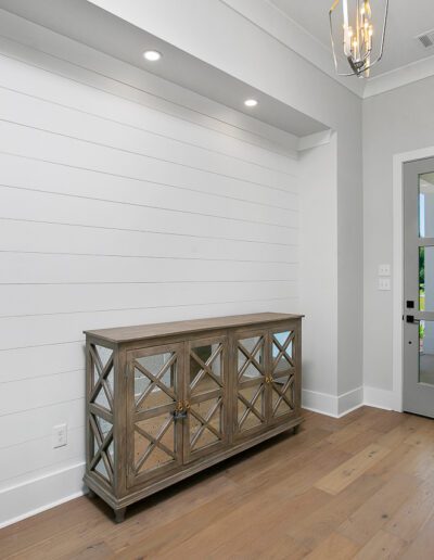 Modern hallway with a decorative console table and shiplap wall detail.