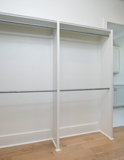Empty walk-in closet with built-in shelving and hanging rods.