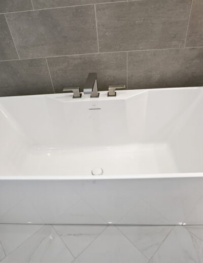 Modern freestanding bathtub in a minimalist bathroom setting.