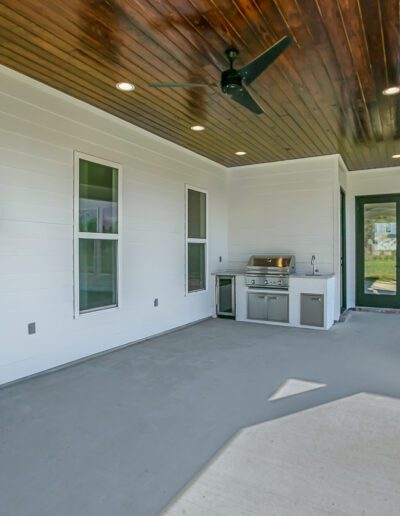 Modern outdoor patio with a fireplace and built-in grill.