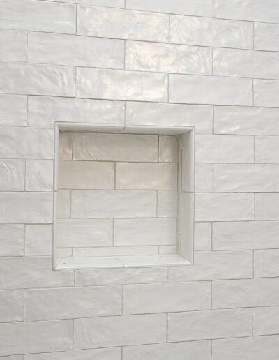 A white, recessed niche in a tiled wall.